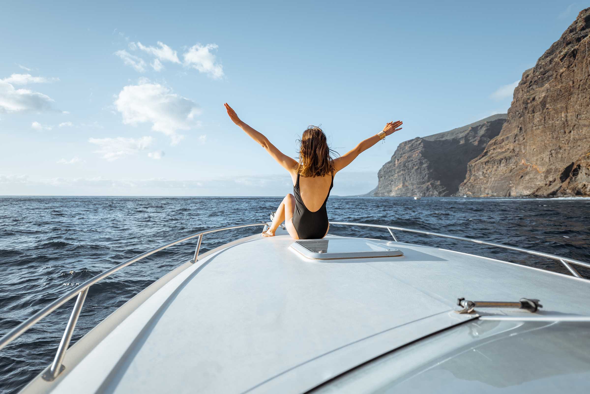 Yacht sailing near a rocky Mediterranean coast